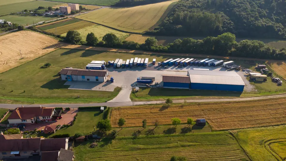 Letecký pohľad na areál firmy vo Vysočanoch s halami a radom návesov